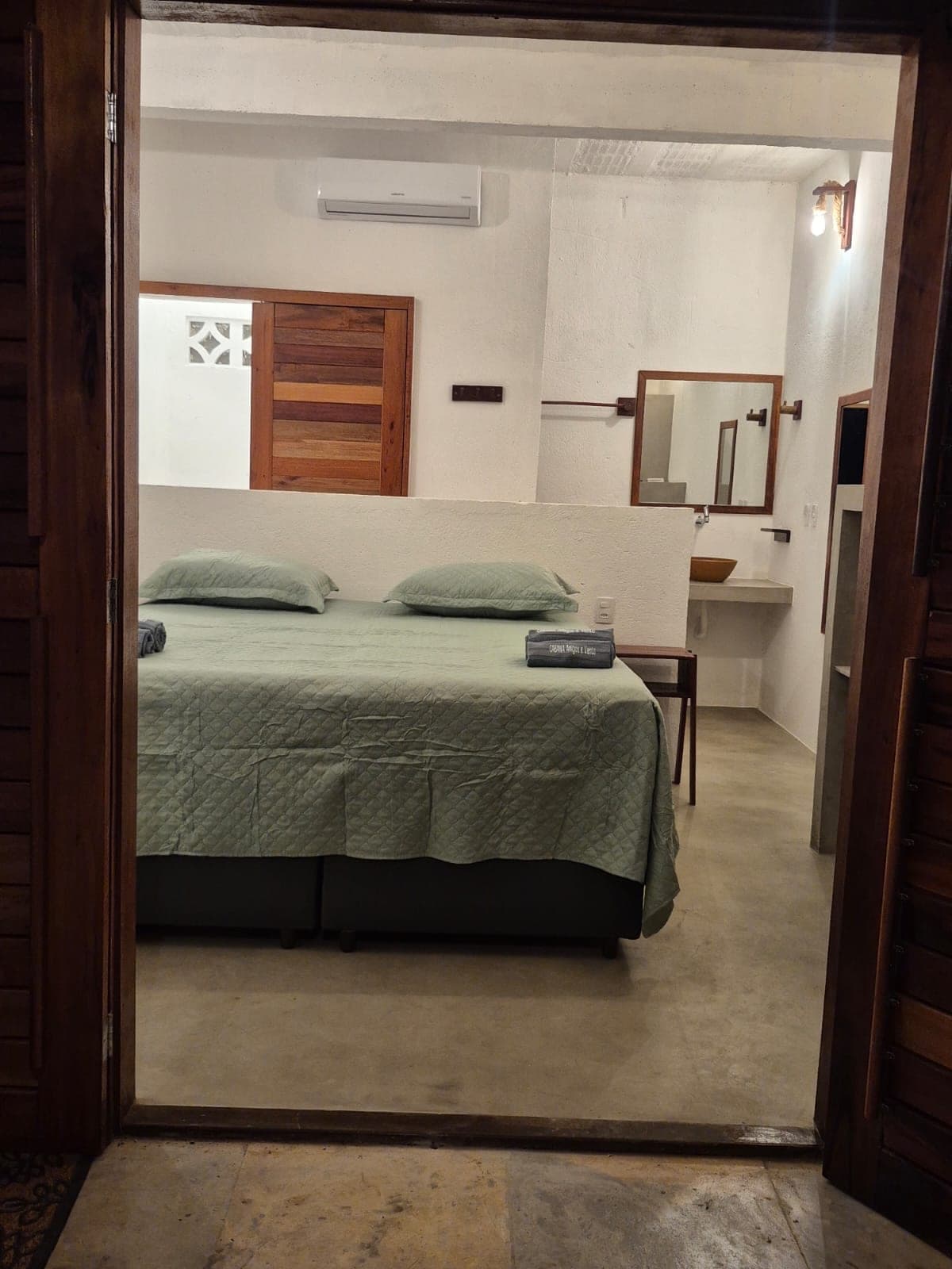 Chambre vue depuis la porte, avec lit double et salle d'eau